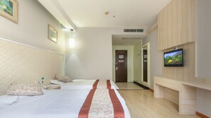 A hotel room with a bed, a TV mounted on the wall, and a wooden cabinet. - Sucha Hotel Wuhan Hankou Railway Station (Wuhan)