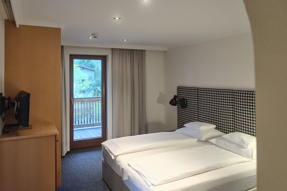 Ropa de cama hipoalergénica y caja de seguridad en la habitación