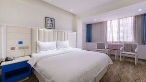 A hotel room with a large bed, a bedside table with a phone, a chair, and a window with curtains. - Sucha Hotel Xian Hangtiancheng Station (Xi'an)