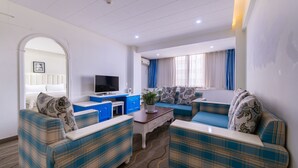A modern living room with a sofa set, a television, and a coffee table. - Sucha Hotel Xian Hangtiancheng Station (Xi'an)