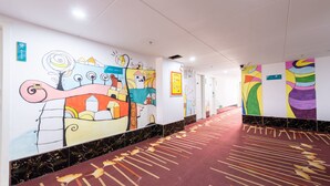 A hotel corridor with colorful murals, a red carpet, and marble flooring. - Sucha Hotel Xian Hangtiancheng Station (Xi'an)
