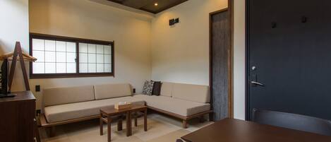 A modern living room with a sofa, a coffee table, and a dining table.