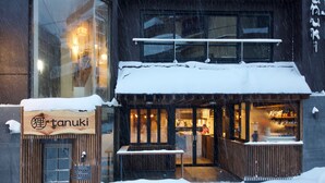 A restaurant with a wooden exterior and snow-covered roof. - Tanuki Nozawa (Nozawaonsen)
