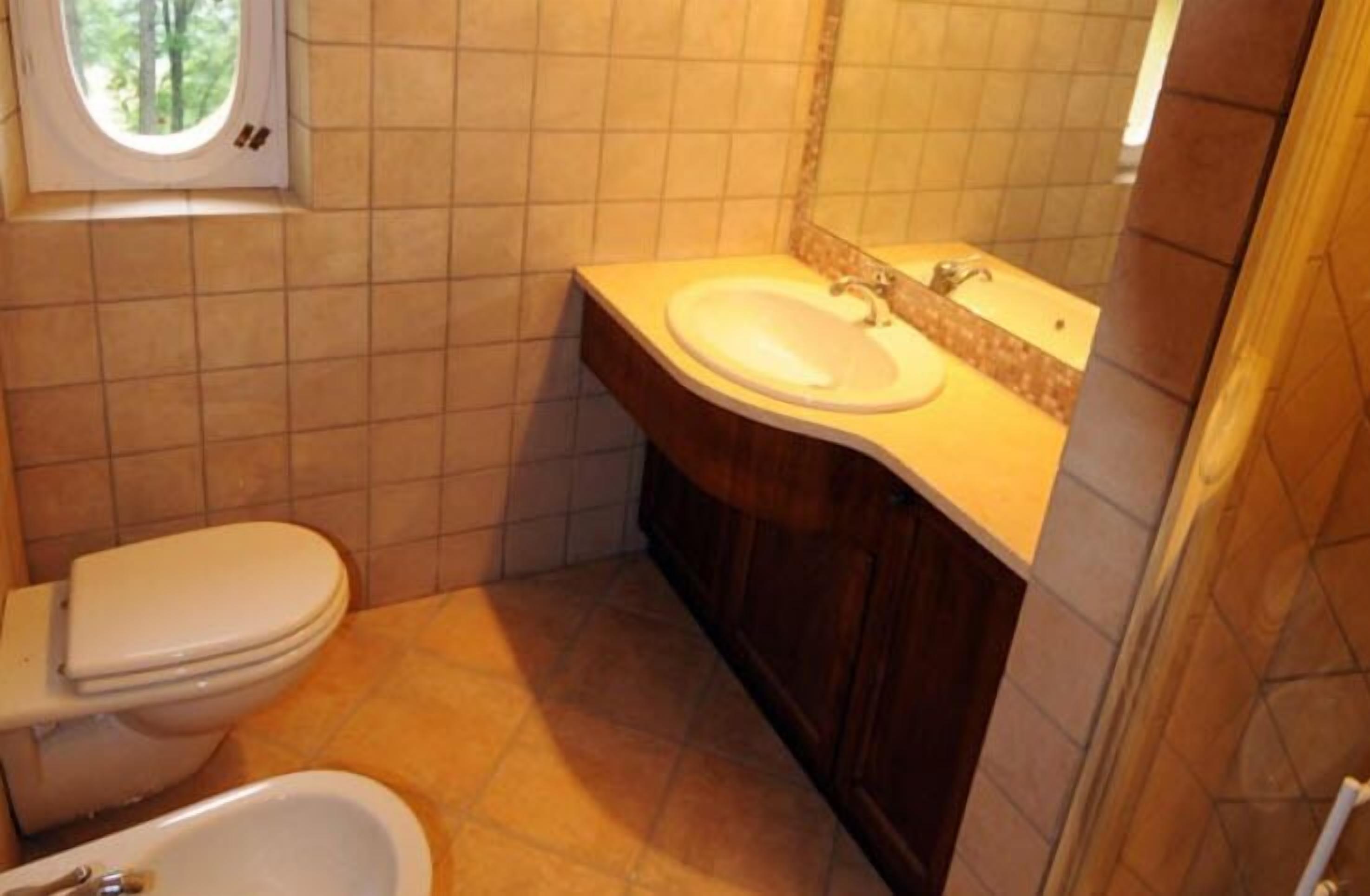 Une salle de bain avec des toilettes, un lavabo et une baignoire.