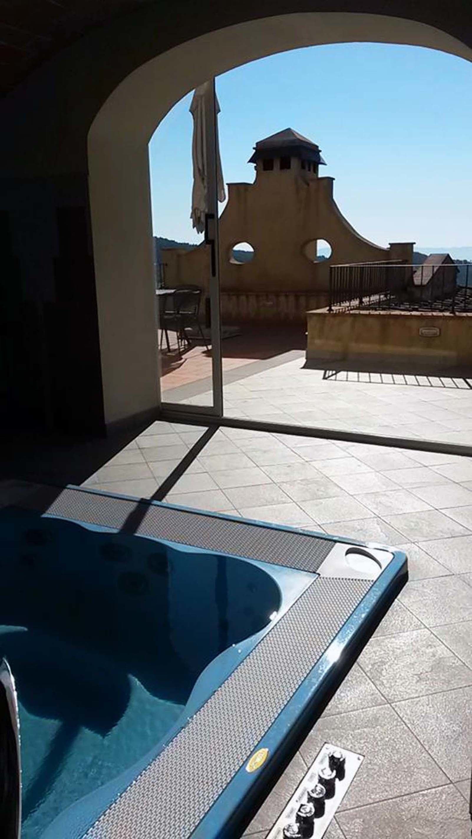 An outdoor swimming pool area with a view of a building with circular windows.