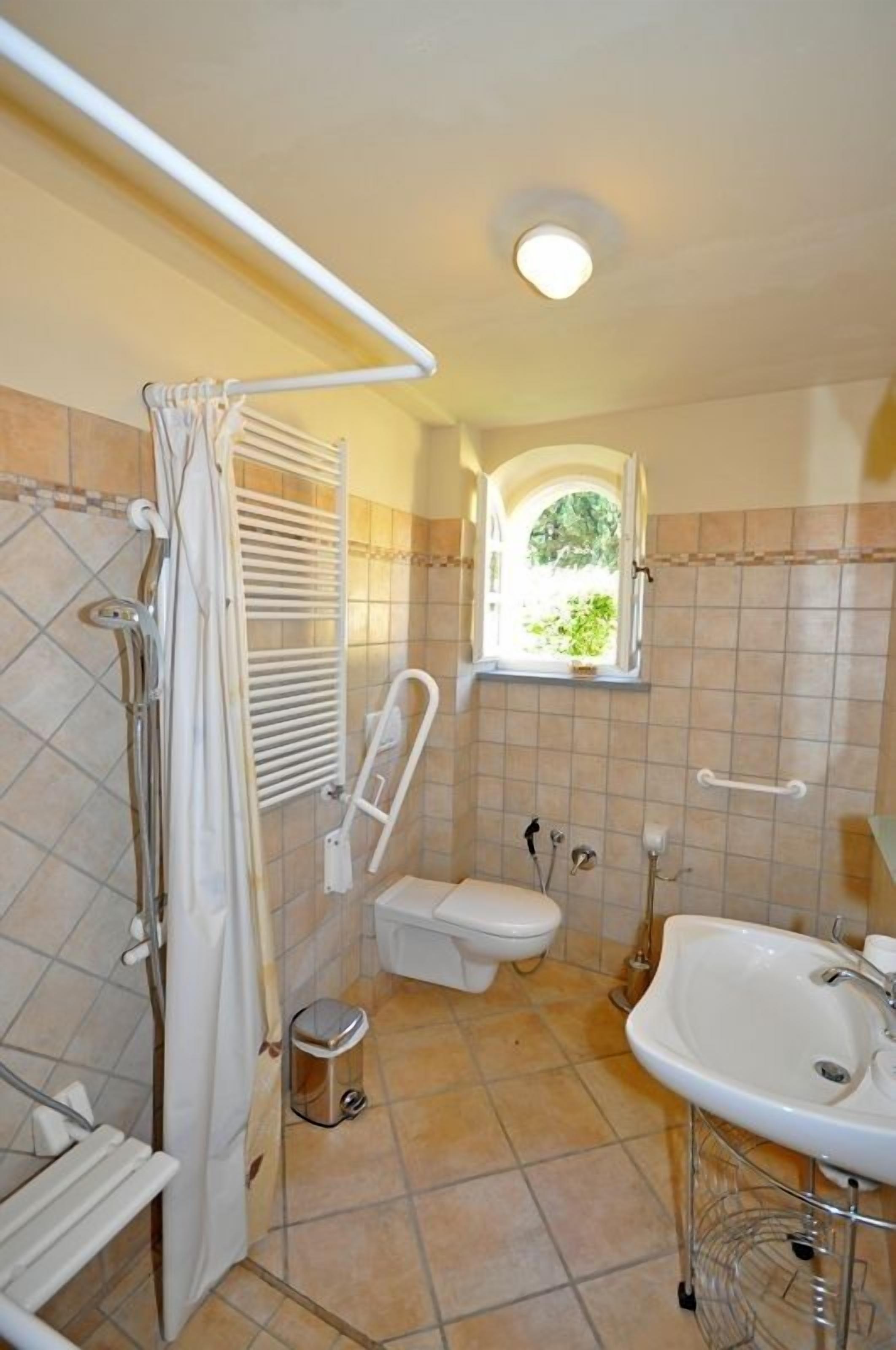 A bathroom with a shower, toilet, and sink.