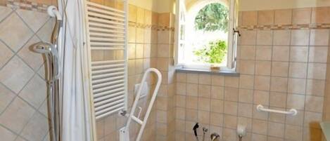 A bathroom with a shower, toilet, and sink.