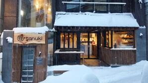 Ein Restaurant mit Holzfassade und einem Schild mit der Aufschrift "tanuki".