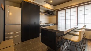 Eine moderne Küche mit integrierter Kochinsel, Barhocker und einem Kühlschrank.