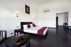 A hotel room with a bed, bedside tables, a desk, and a chair. - Grand Tamarind Lake (Kataragama)