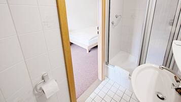 A bathroom with a shower, toilet, and sink.