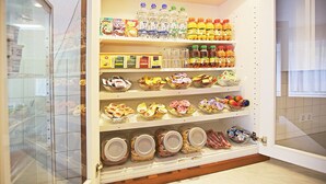 A kitchen with shelves stocked with various food items, including jars, bottles, and packaged goods.