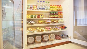 A kitchen with shelves stocked with various food items, including jars, bottles, and packaged goods.