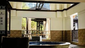 A spa area with a hot tub, wooden deck, and a view of the outdoors. - Heyuan Mels Welton Evergreen Lake Hotel (Heyuan)