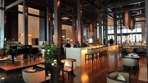 A spacious lobby with a grand piano, a bar area, and seating arrangements. - Heyuan Mels Welton Evergreen Lake Hotel (Heyuan)