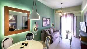 Una sala de estar moderna con sofá, mesa de comedor, sillas y un espejo grande.