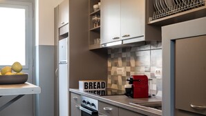 Una cocina compacta con electrodomésticos modernos, horno integrado y cafetera.