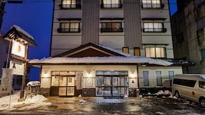 Un hôtel dont l’entrée est recouverte de neige et qui présente un design moderne.