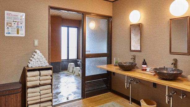 Une salle de bain moderne avec un meuble-lavabo en bois, deux grands lavabos et un porte-serviettes.