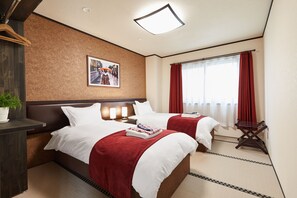 A hotel room with two beds, a large window with red curtains, a wall-mounted picture, and a bedside table with a lamp. - The Address Akakura (Myoko)