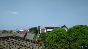 A residential area with modern houses, a red-roofed building, and green trees. - De Sutami Pasteur Villa by HouseinBandung (Bandung)