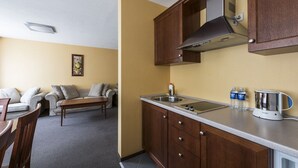 A compact kitchen with wooden cabinets, a stainless steel sink, and a coffee maker. - ORO Dubingiai (Giraiciai)