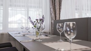 A dining table set with wine glasses, cutlery, and a vase with flowers. - ORO Dubingiai (Giraiciai)