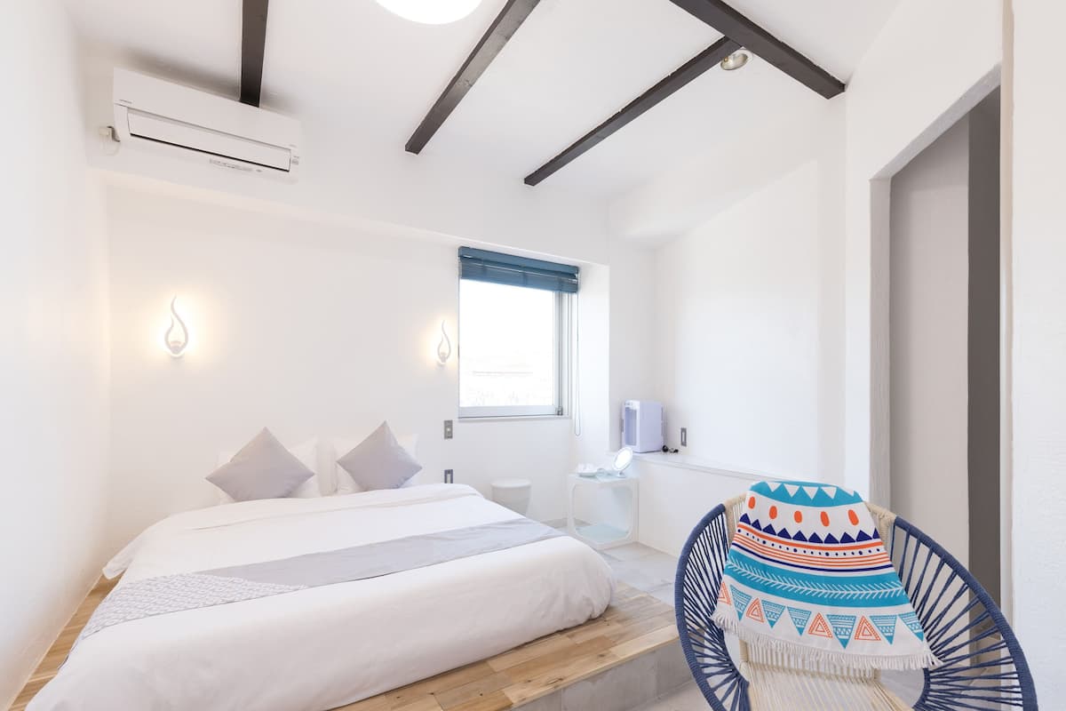 Une chambre à coucher moderne avec un lit, une table de chevet et une chaise.