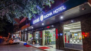 L’entrée d’un hôtel, avec une enseigne indiquant « SUCHA HOTEL ».