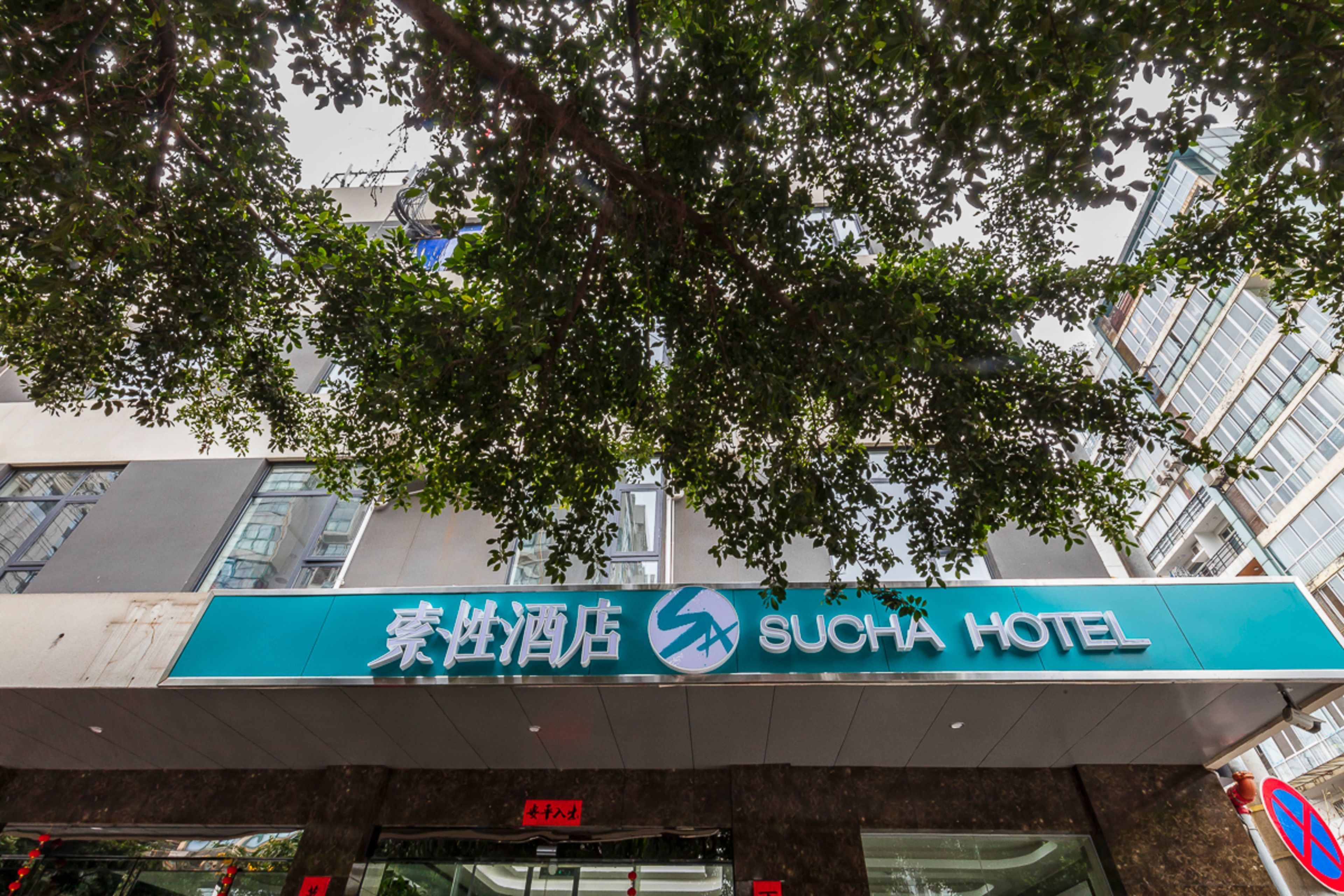 A hotel sign with the name "SUCHA HOTEL" and a logo.
