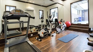 A gym with treadmills, elliptical machines, and exercise balls. - Capital O 36457 Boulevard Madiwala (Bengaluru)