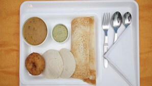 A white tray with a crepe, two round fried items, and two small bowls of sauce. - OYO 23300 Seabreeze Residency (Puducherry)