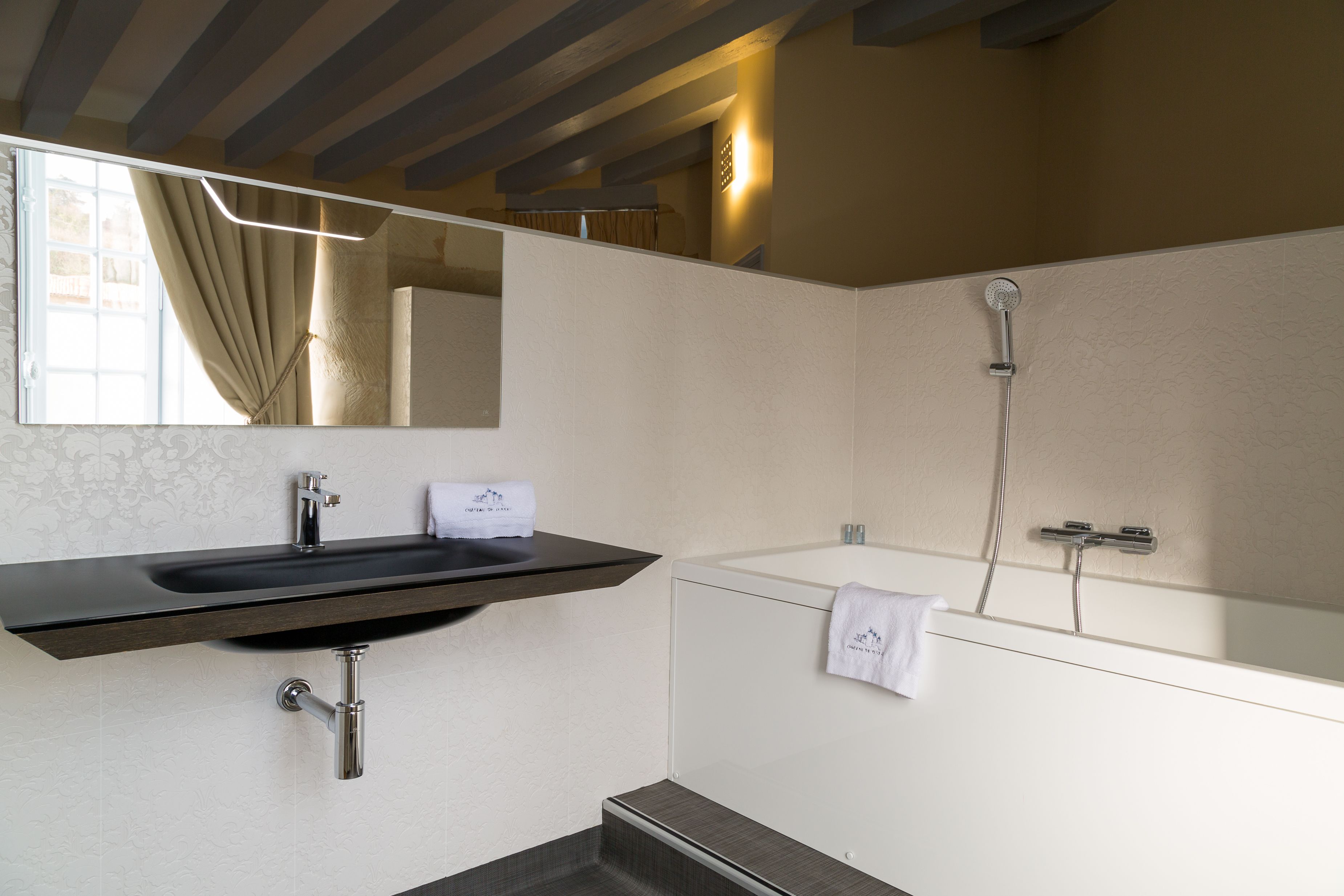 Ein modernes Badezimmer mit Waschbecken, Spiegel und Dusche.