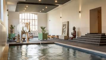 Una piscina cubierta, tumbonas