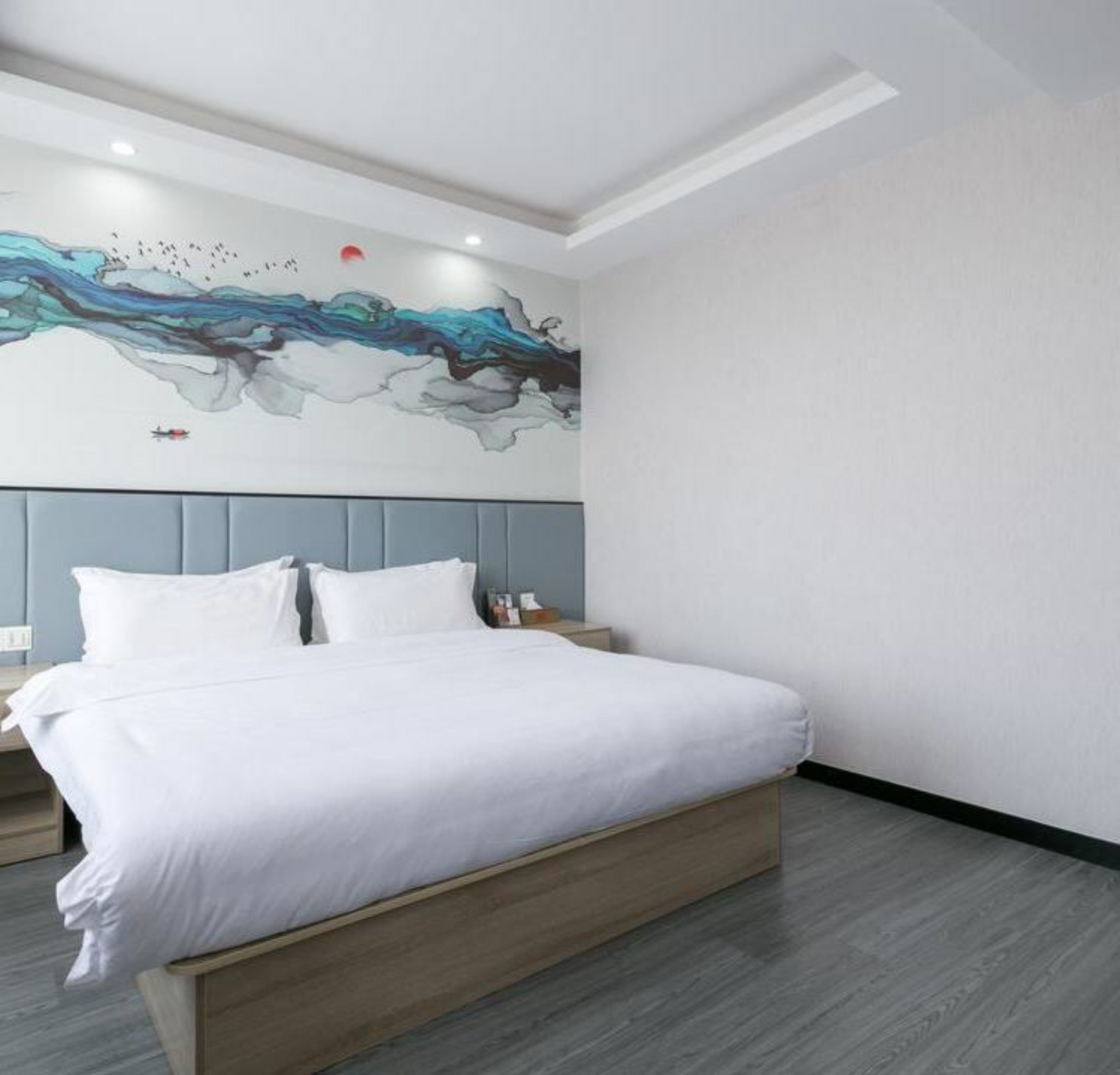 A modern bedroom with a large bed, a grey headboard, and a wall mural depicting a blue and green abstract design.