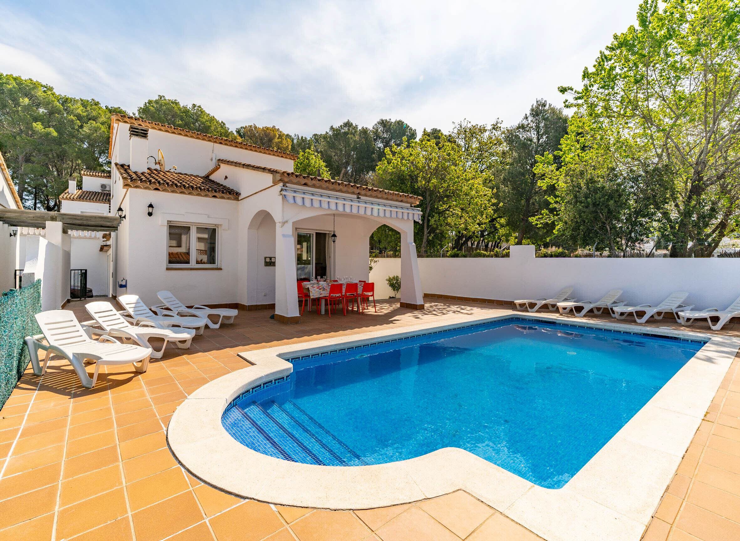 A private pool area with a white building, outdoor seating, and lounge chairs.