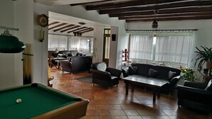 A living room with a pool table, sofas, and a dining area. - BonDia (Rasnov)