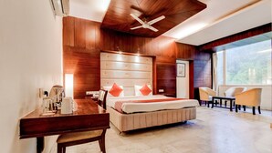 A modern hotel room with a large bed, a desk, and a chair. - OYO 39725 Hotel Regent Continental (New Delhi)
