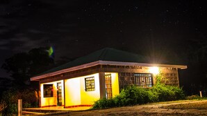 Un petit bâtiment d’un seul étage, doté d’un toit en pente et éclairé par un éclairage extérieur.