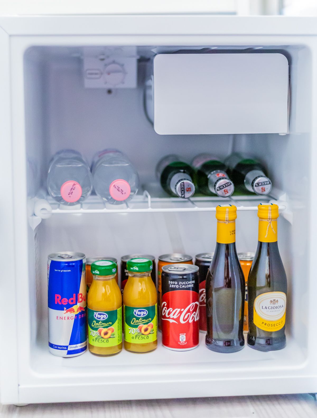 A refrigerator with various beverages including energy drinks, juices, and bottled water.