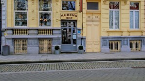 Un edificio amarillo con un letrero que dice "RUBENS HOF".