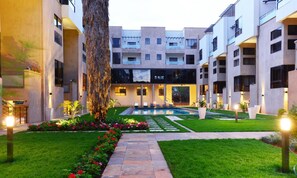 A courtyard with a swimming pool, surrounded by modern buildings with balconies and large windows. - The Courtyard at Vanga (Nairobi)
