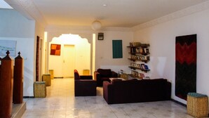 Un salón amplio con chimenea, asientos cómodos y una estantería.