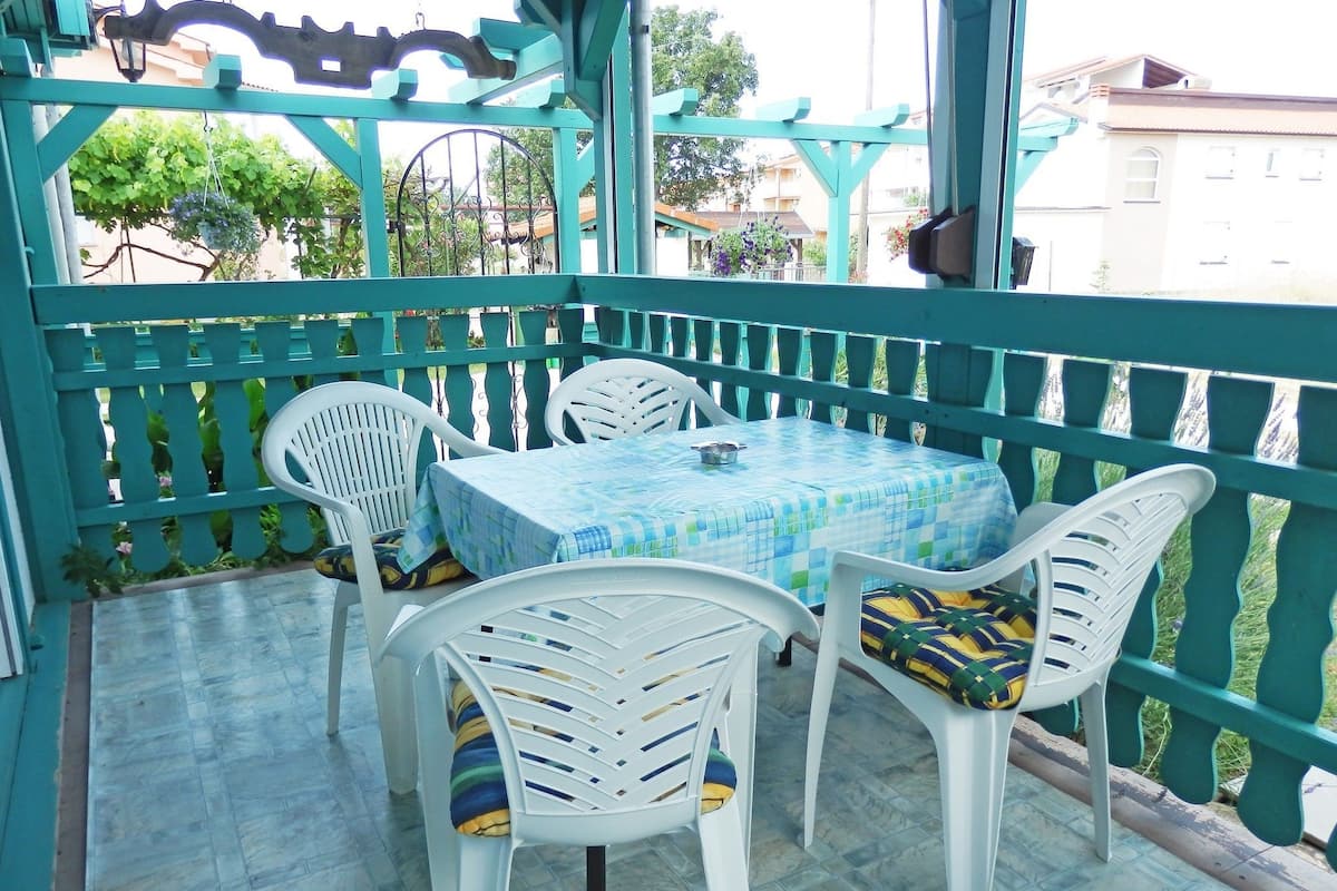 Un patio techado al aire libre con una mesa y cuatro sillas.