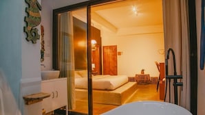 Une salle de bain moderne avec une baignoire sur pieds, une douche à parois de verre et un lavabo blanc.