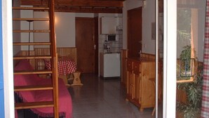 A room with a bunk bed, a small kitchen area, and a dining table. - T2 MEZZANINE + TERRACE SAINT CYPRIEN BEACH (Saint-Cyprien Plage)