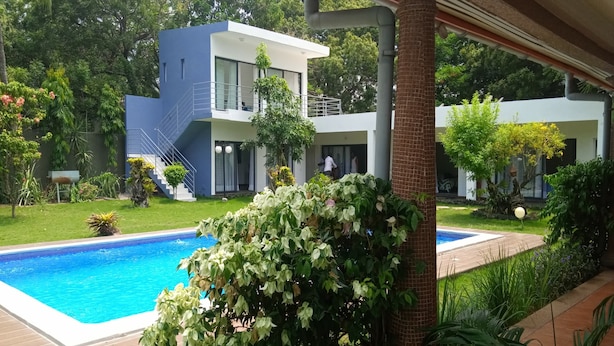 A modern two-story house with a swimming pool, surrounded by lush greenery and a well-maintained lawn. - Résidence Akwaba T7 (Abidjan)
