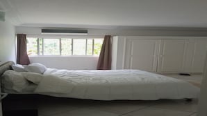 A bedroom with a bed, a window with curtains, a wardrobe, and a tiled floor. - Résidence Akwaba T7 (Abidjan)