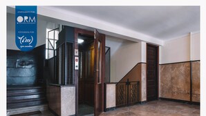 A modern elevator with a marble floor and a wooden door. - ORM- Saraiva de Carvalho apartments (Porto)