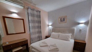 A bedroom with a bed, bedside tables, a mirror, and a wall-mounted picture. - Corfu Island Apartment 40 (Corfu)